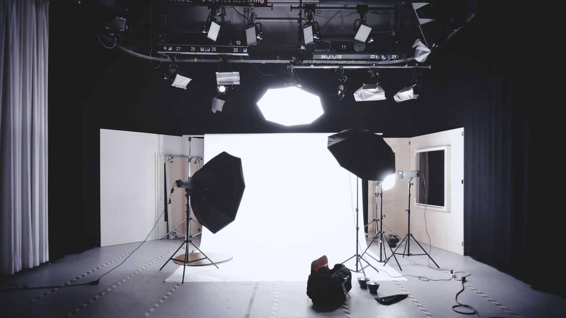 Estudio de fotografía con equipo de iluminación y fondo blanco.