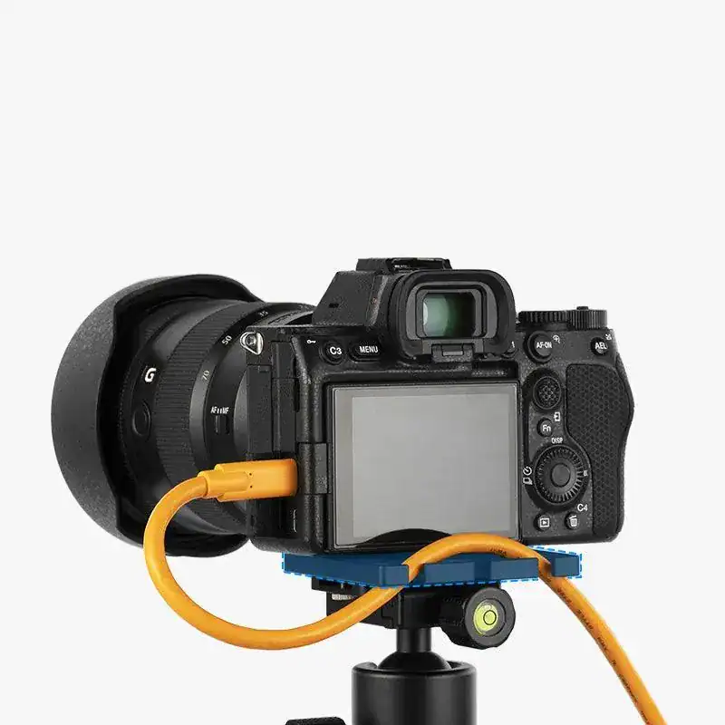 Cámara réflex digital con cable de conexión y accesorios para fotografía profesional.