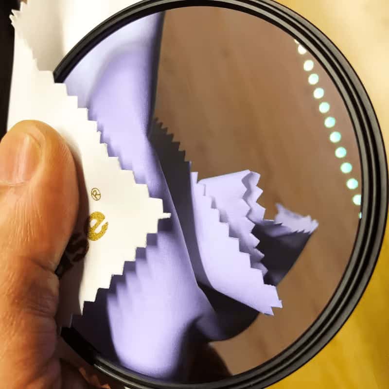 Paño de limpieza para lentes y filtros de 12x17cm en uso.