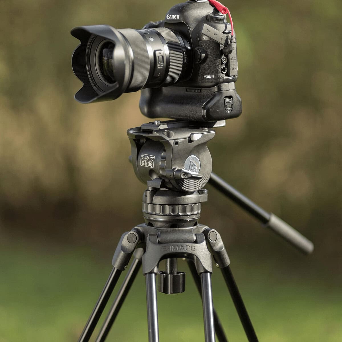 Trípode profesional con cámara Canon y cabezal fluido para fotografía.